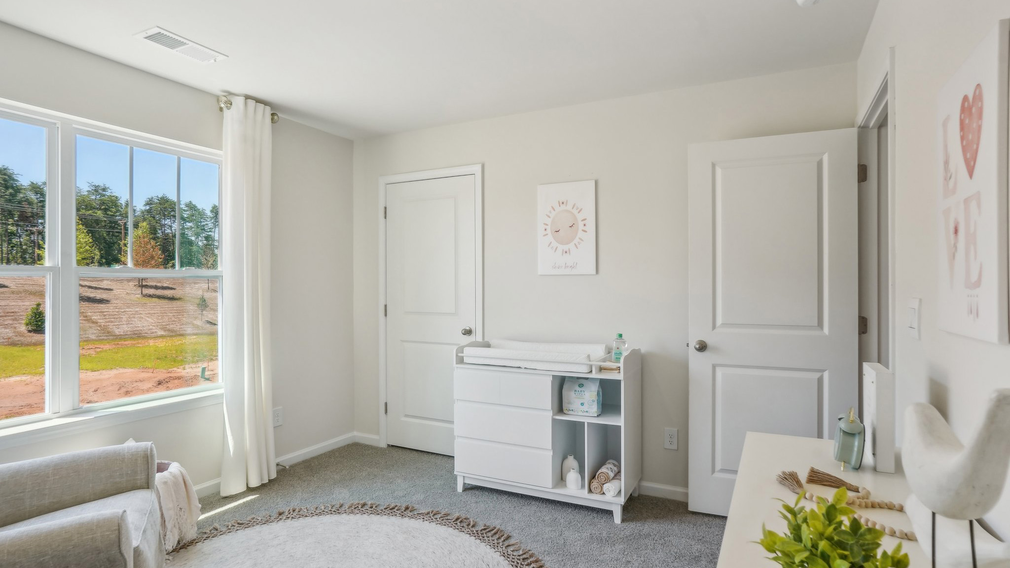 Model carpeted bedroom with large window
