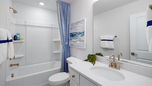 Bathroom with bathtub, white cabinets and counters