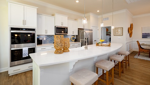 Kitchen with large island, white counters and cabinets