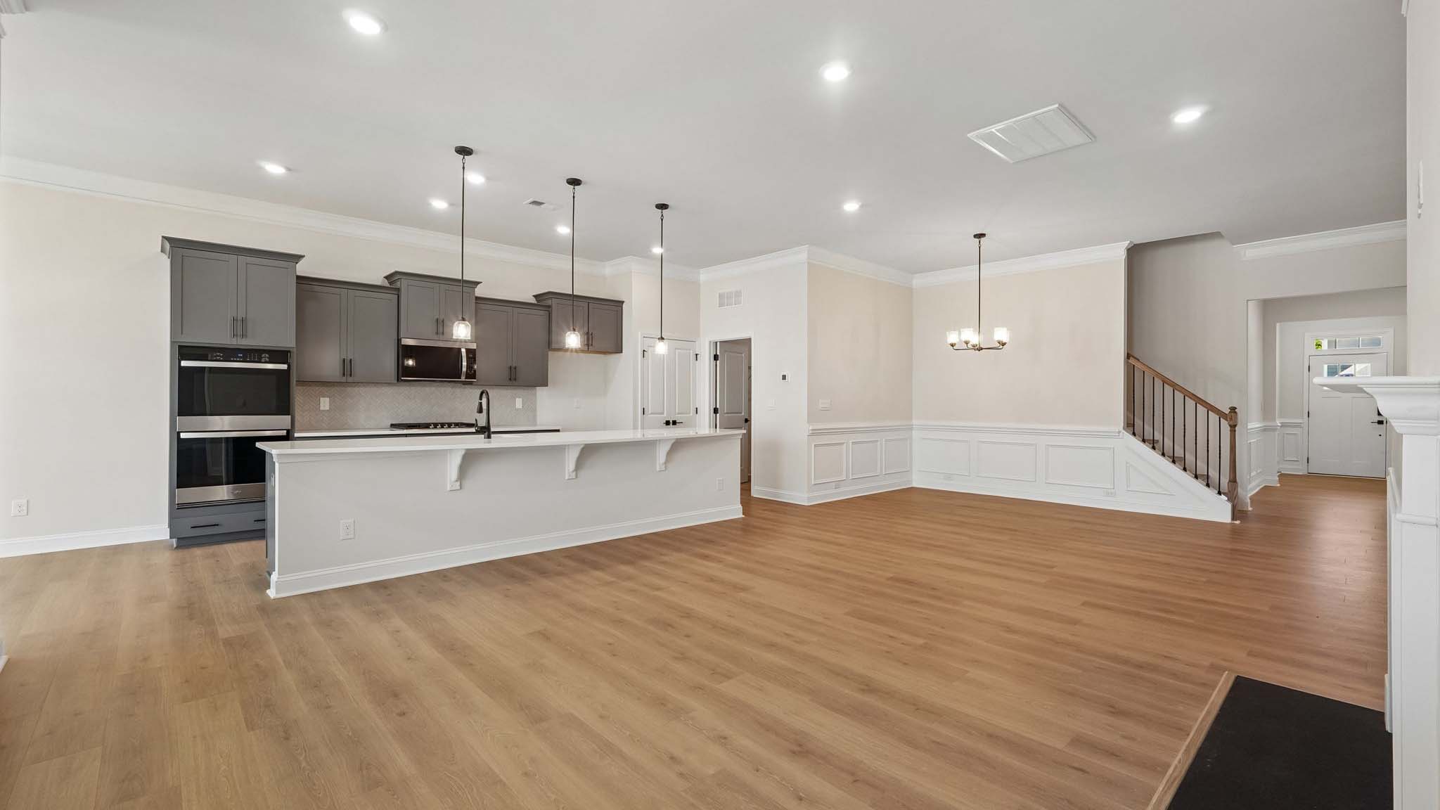 Open living room with wood floors, three windows, and fireplace