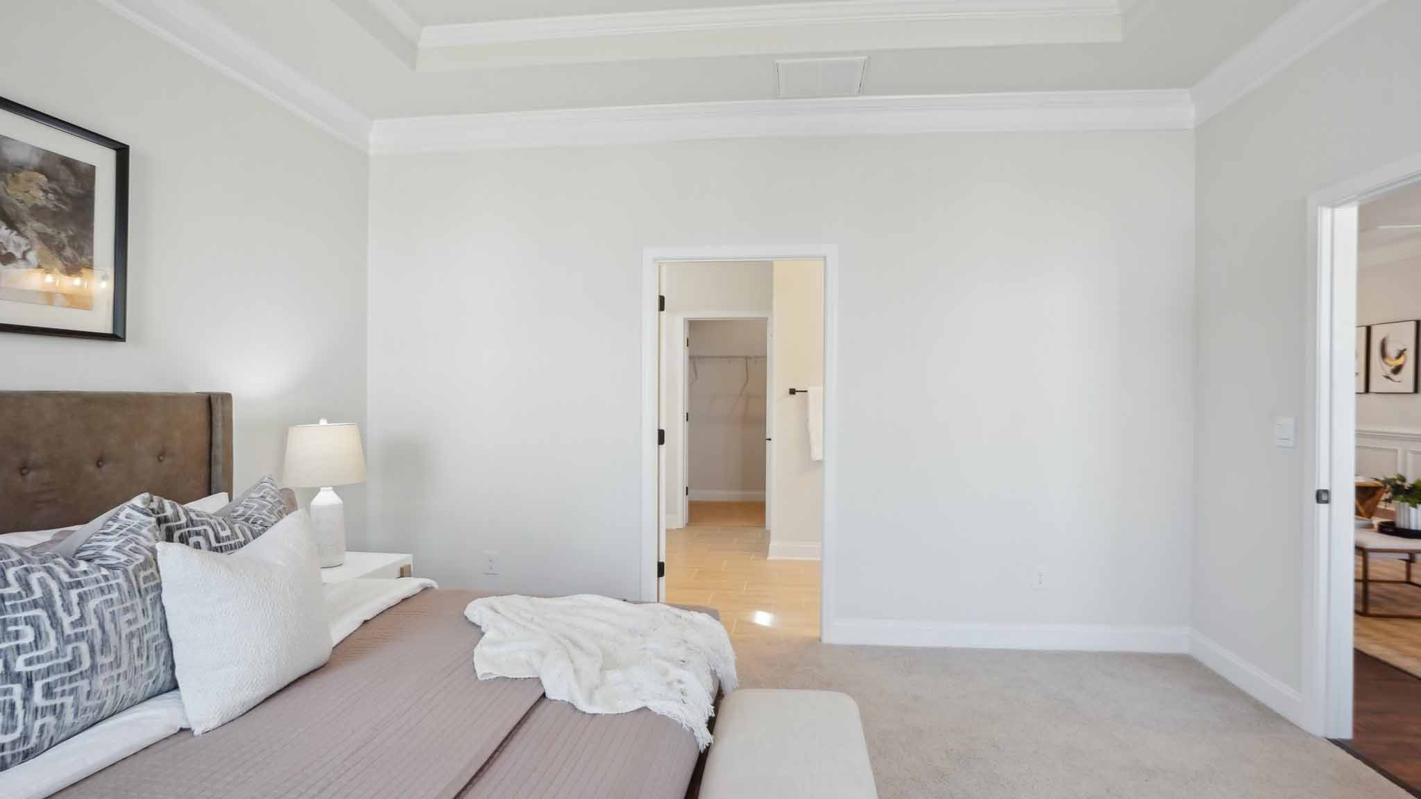 Primary bedroom with wood floors, and two large windows