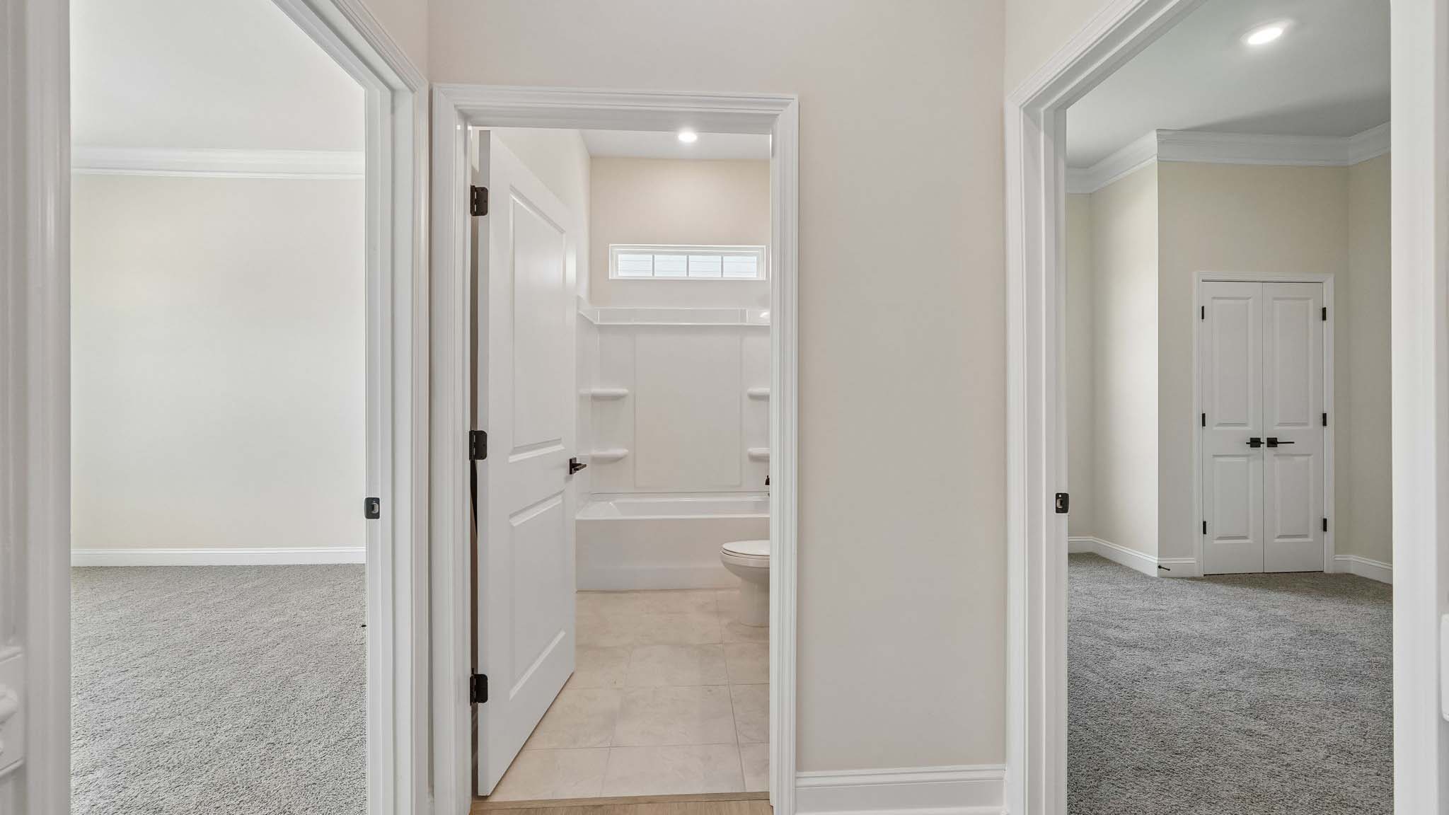 Kitchen and island with wood floors, white cabinets and counters, stainless steel appliances, and seating at island bar