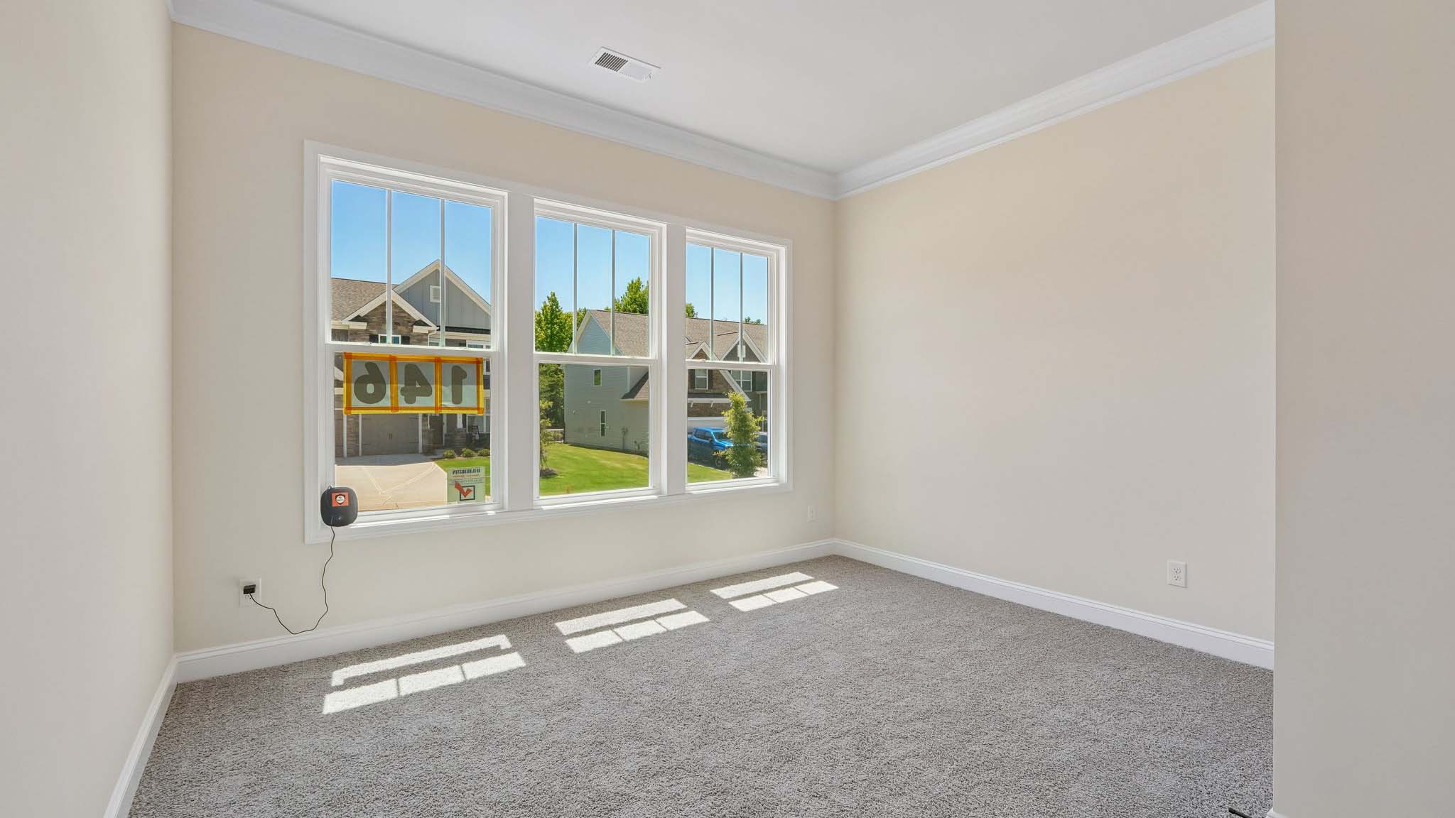 Carpeted bedroom three large windows