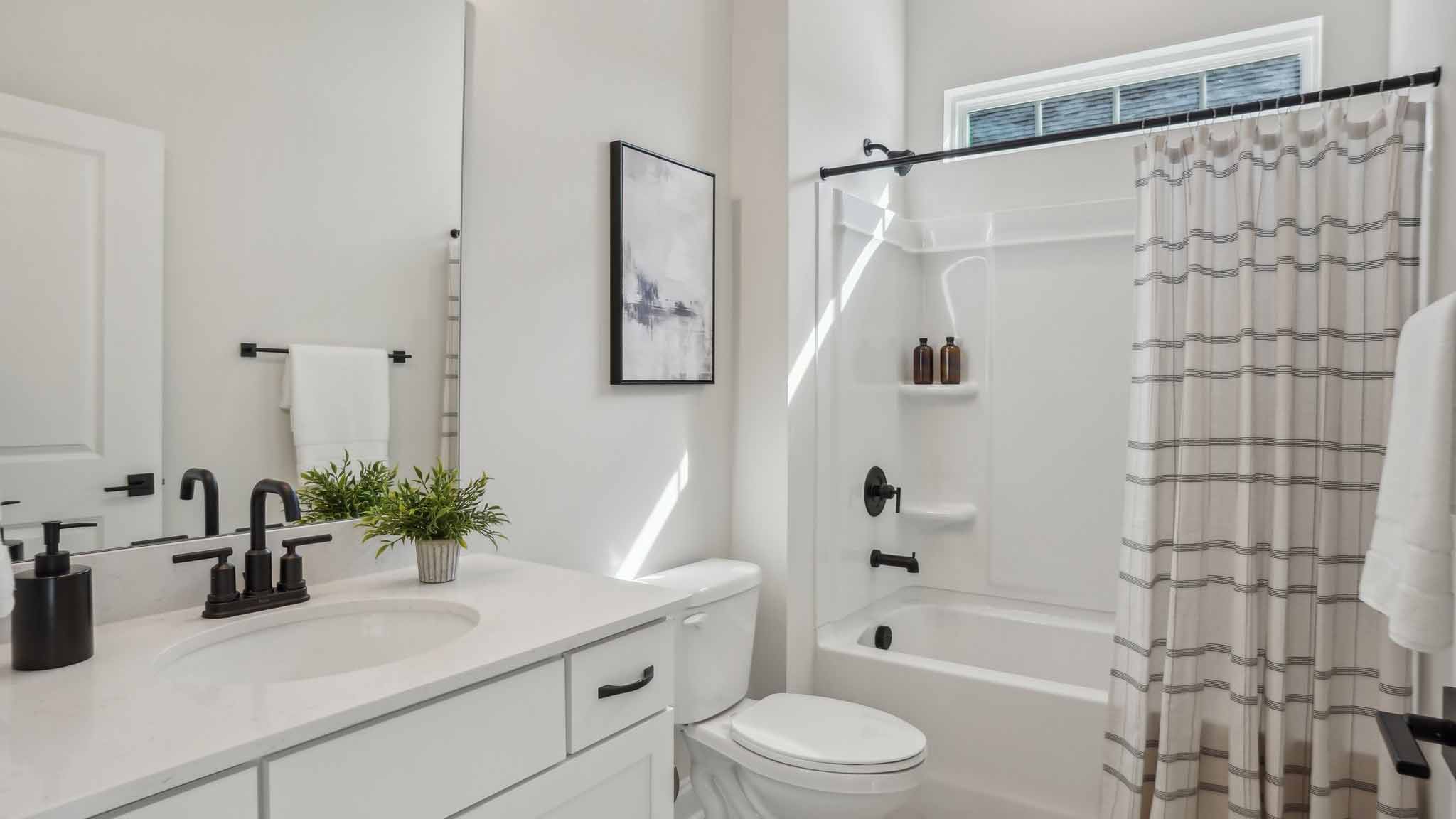 Bathroom with bathtub, white cabinets and counters