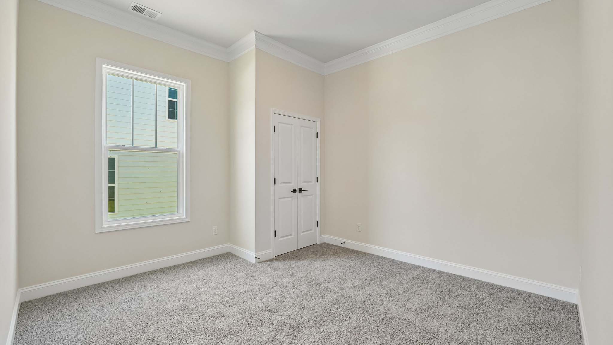 Carpeted bedroom three large windows