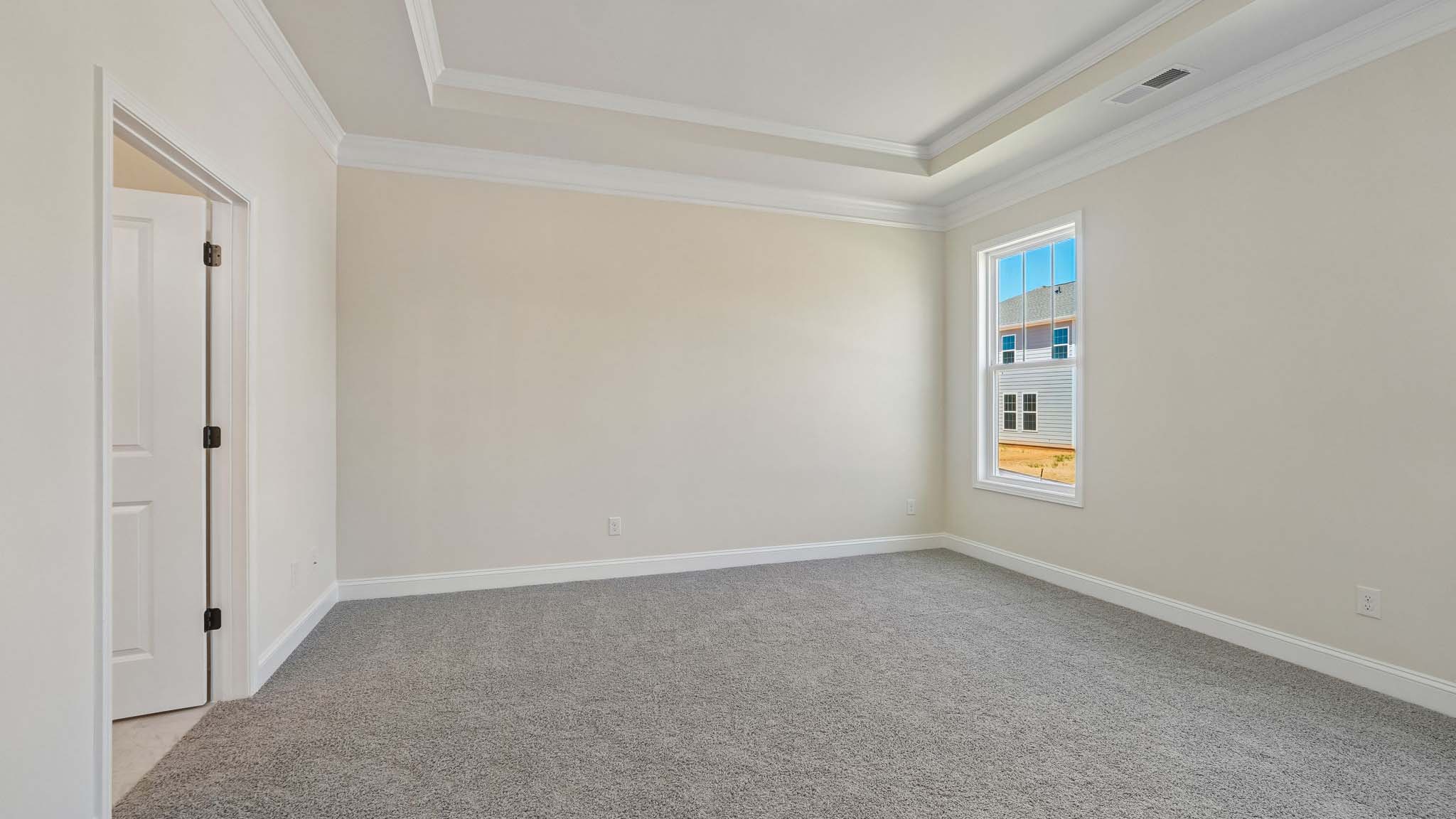 Primary bedroom with wood floors, and two large windows