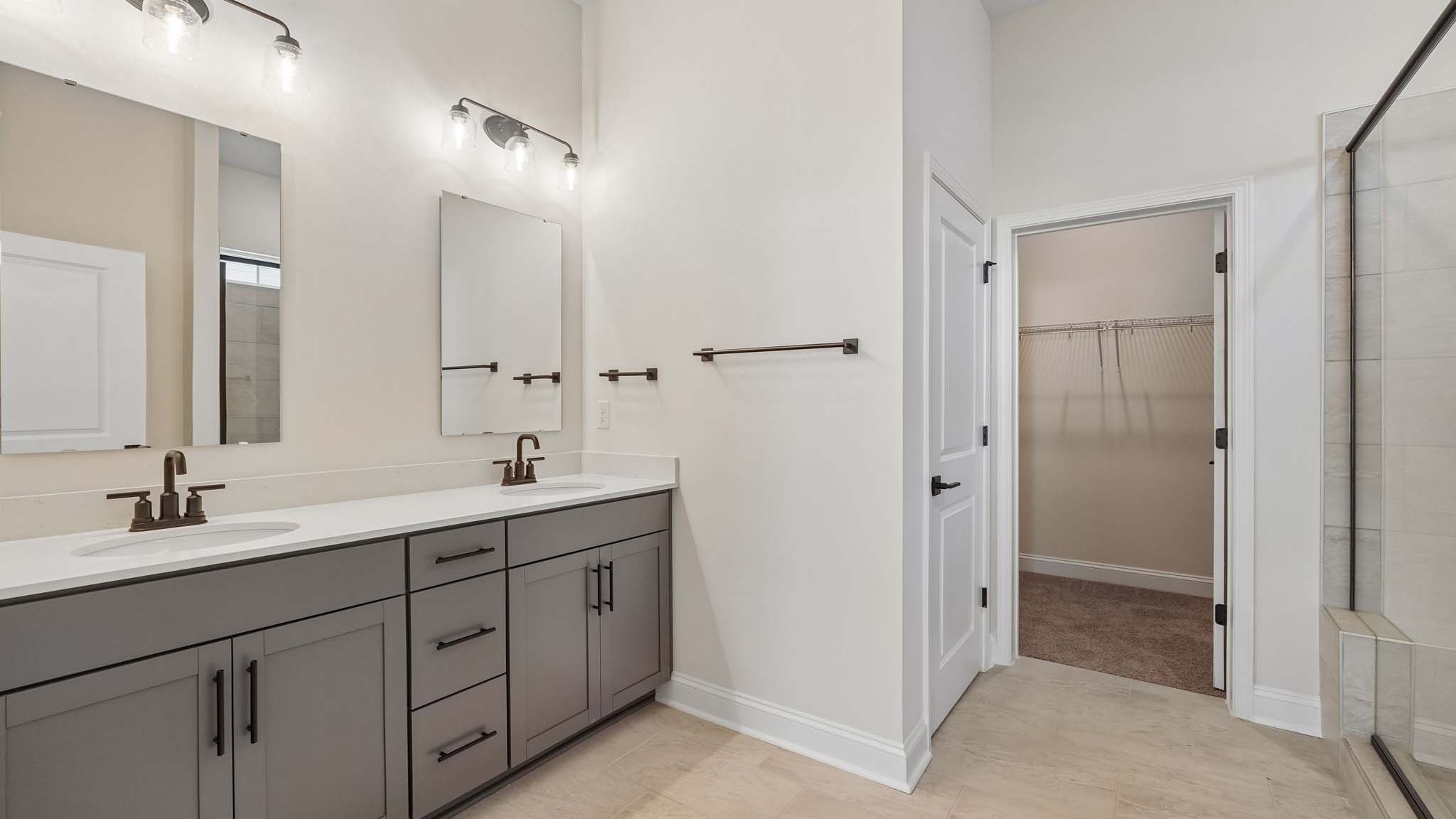 Primary bathroom with double sinks, white cabinets