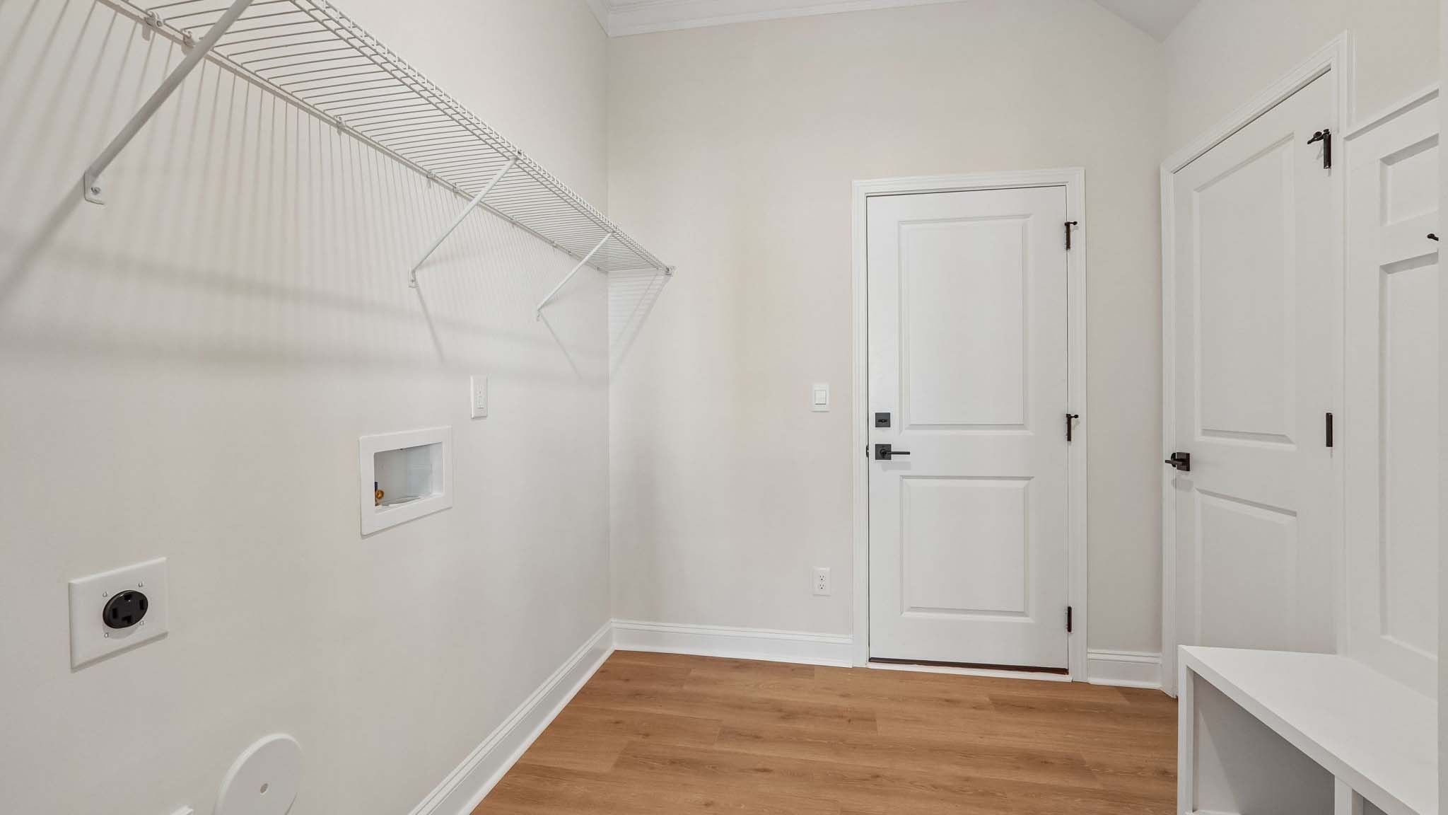 Laundry room with built in racks above machines