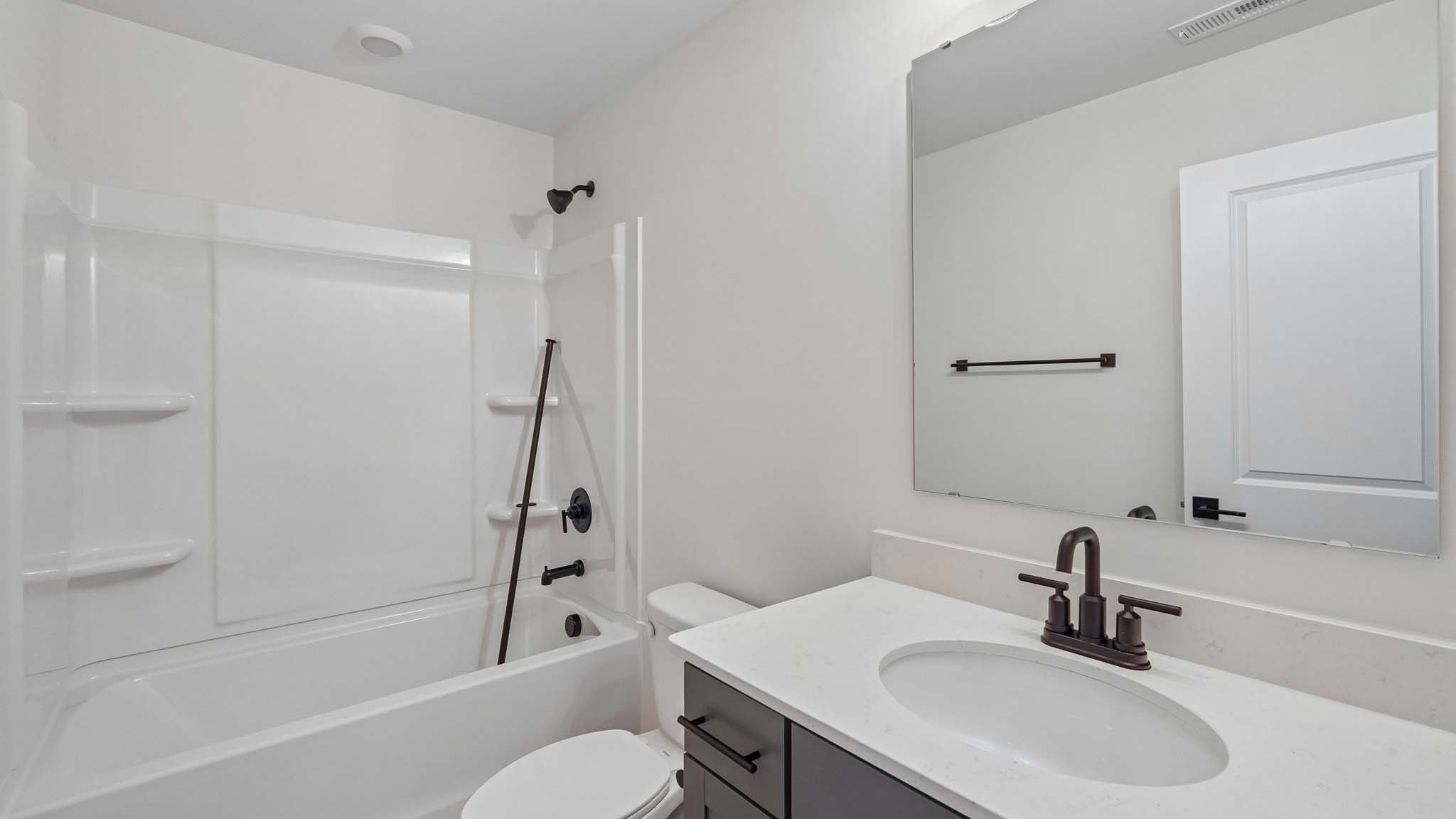 Bathroom with bathtub, white cabinets and counters