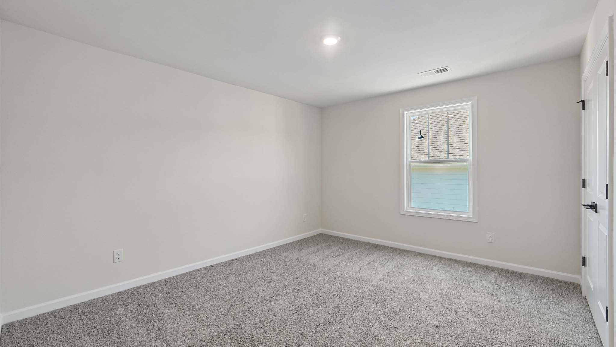 Carpeted bedroom with large window