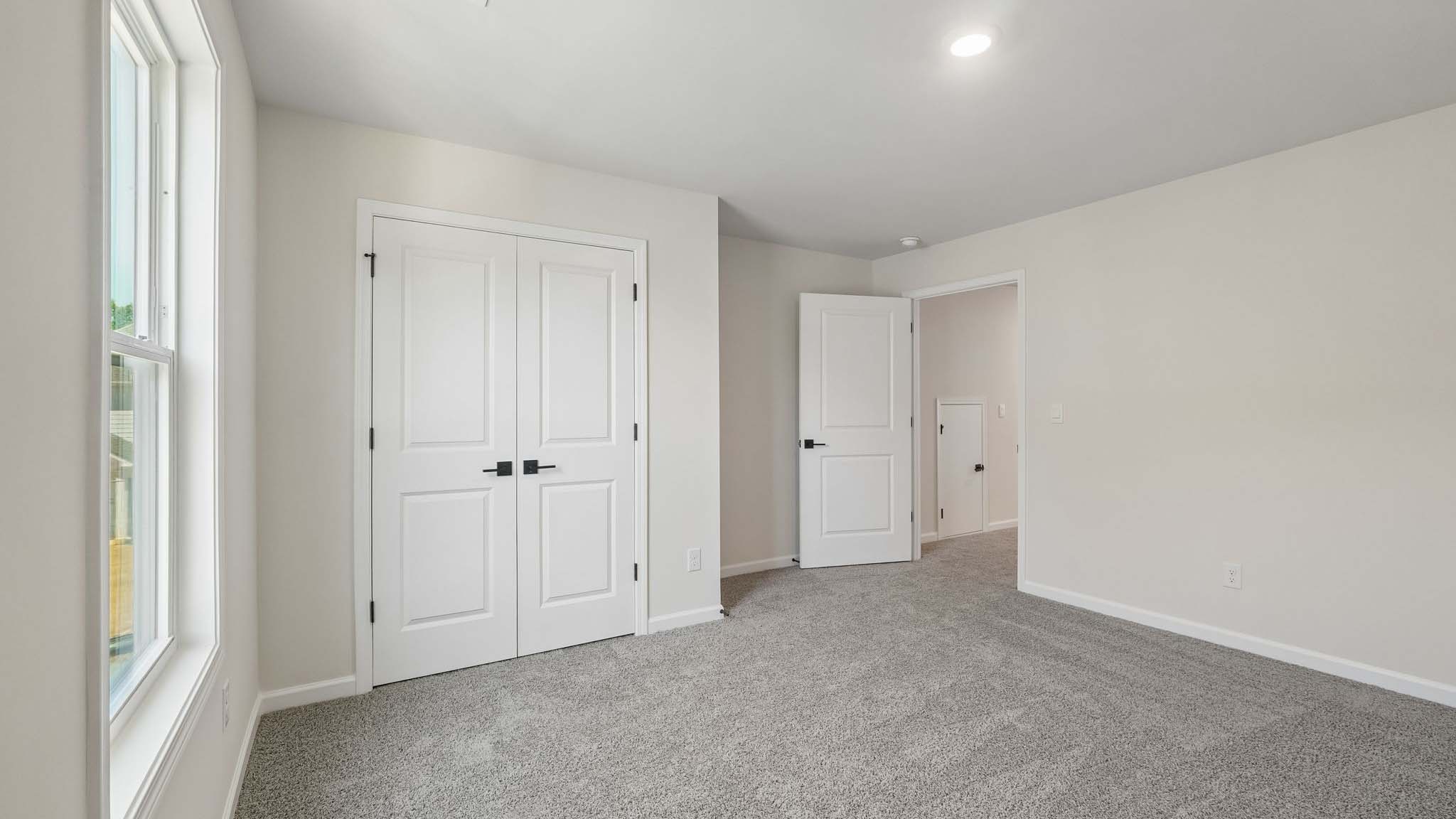 Carpeted bedroom with large window
