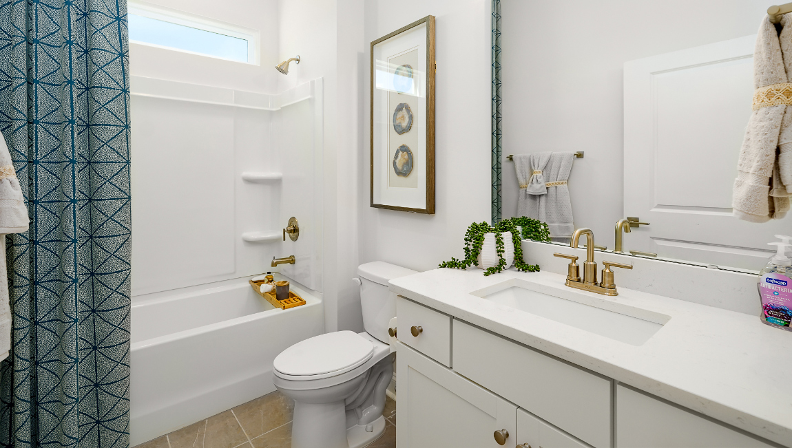 Bathroom with bathtub, white cabinets and counters