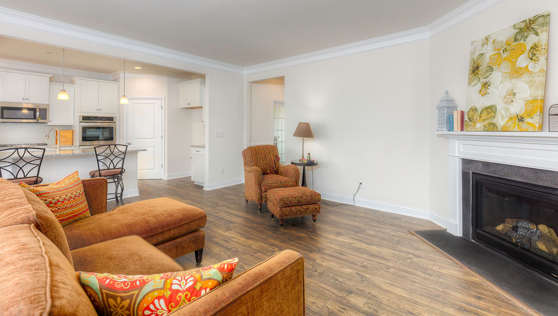 Open concept family room with wood floors, 3 large windows, and fireplace