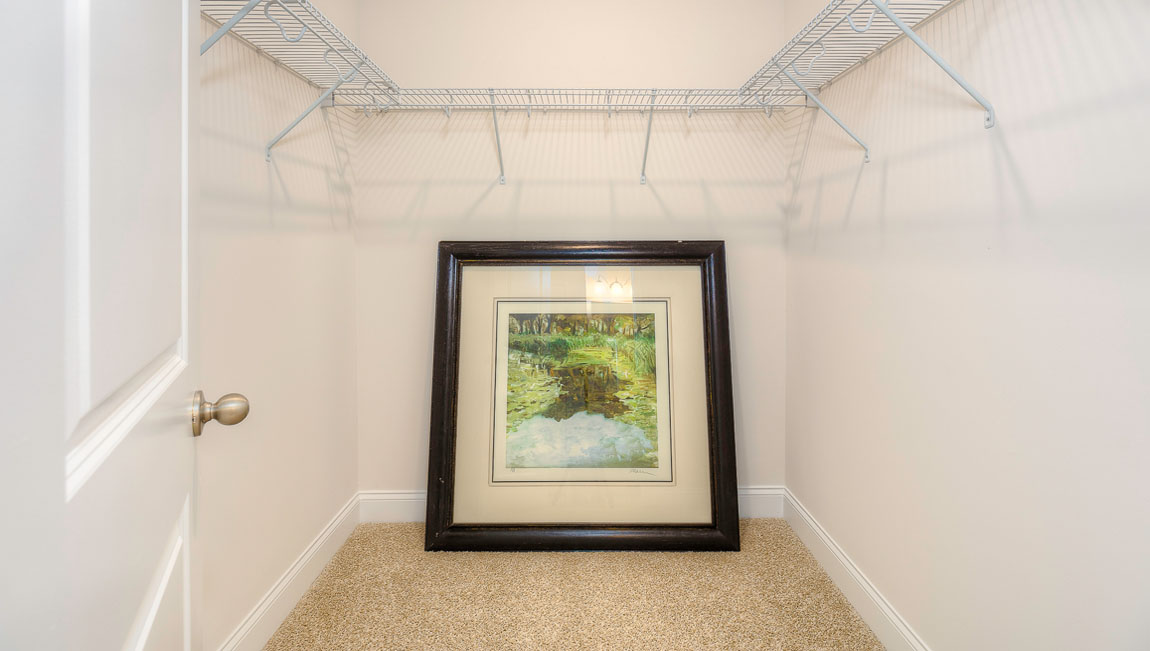 Carpeted walk in closet with built in hanger racks