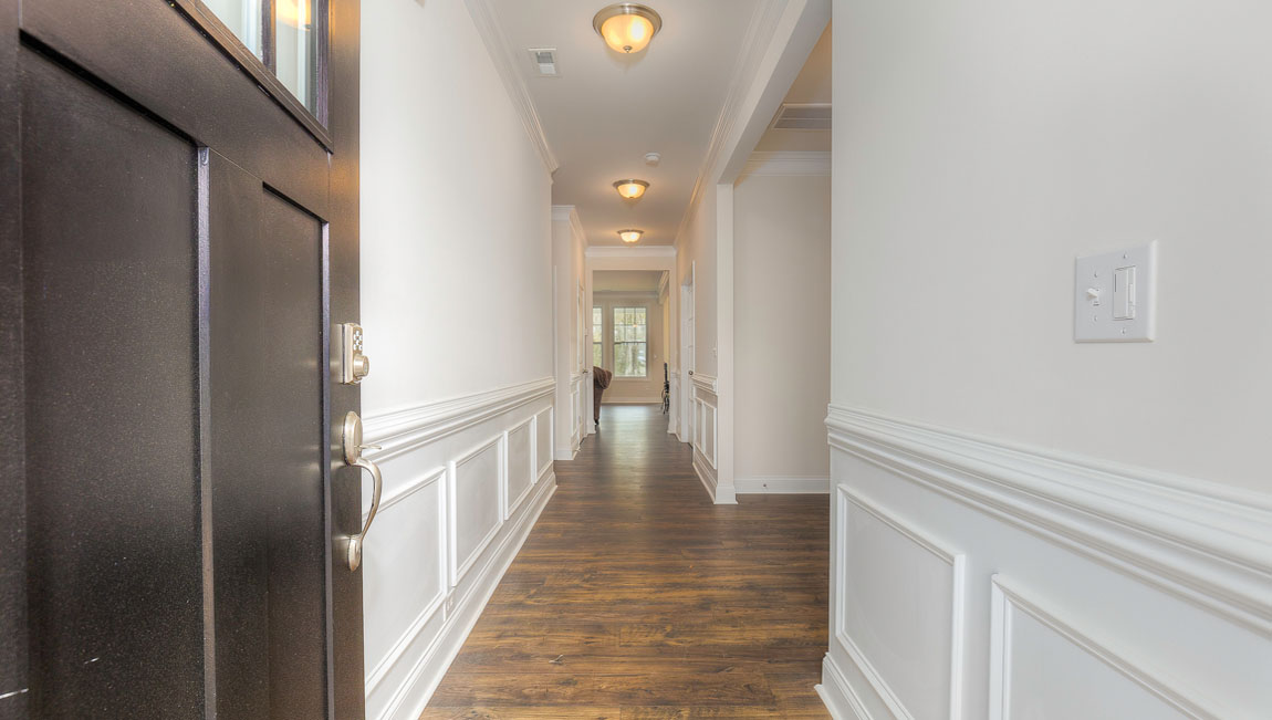 Welcoming foyer with wood floors, view of front door, and edge of dining room