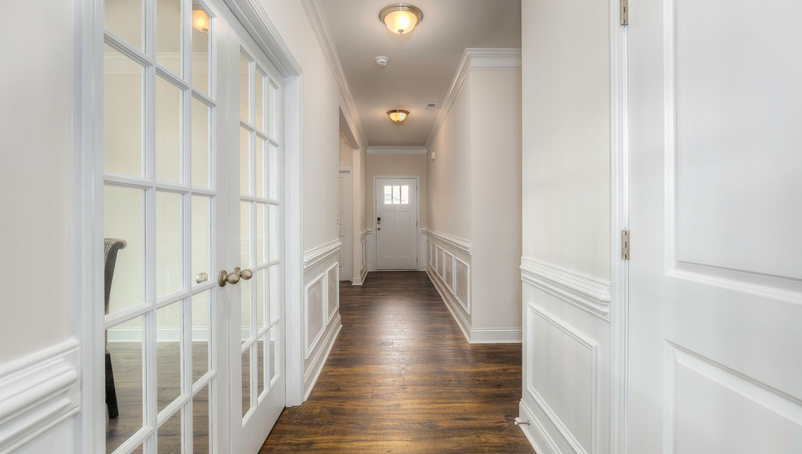 Welcoming foyer with wood floors, view of front door, and edge of dining room