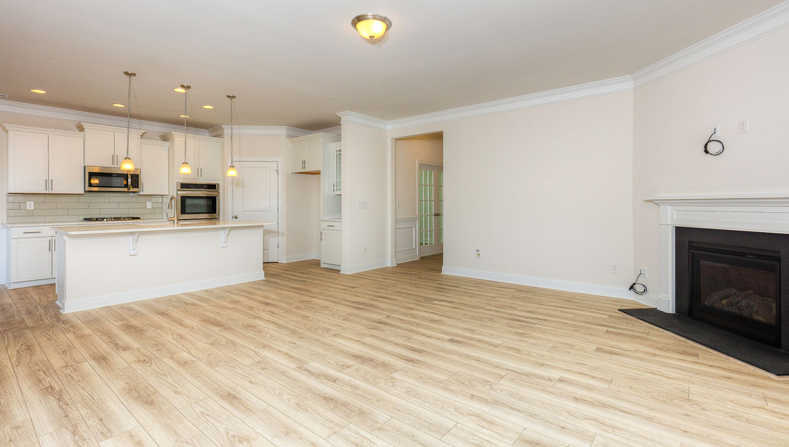 Open concept family room with wood floors, 3 large windows, and fireplace