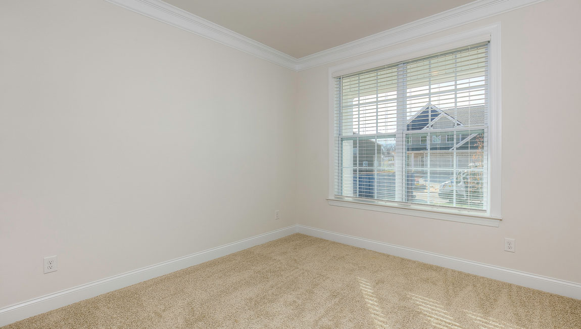 Carpeted bedroom with windows