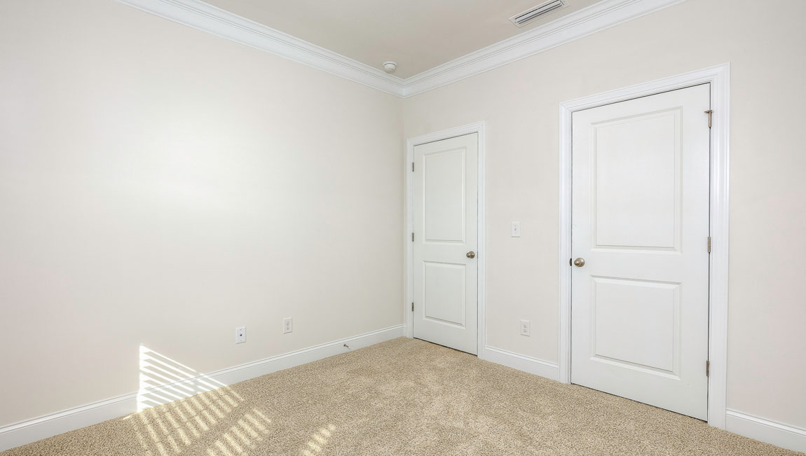Carpeted bedroom with windows