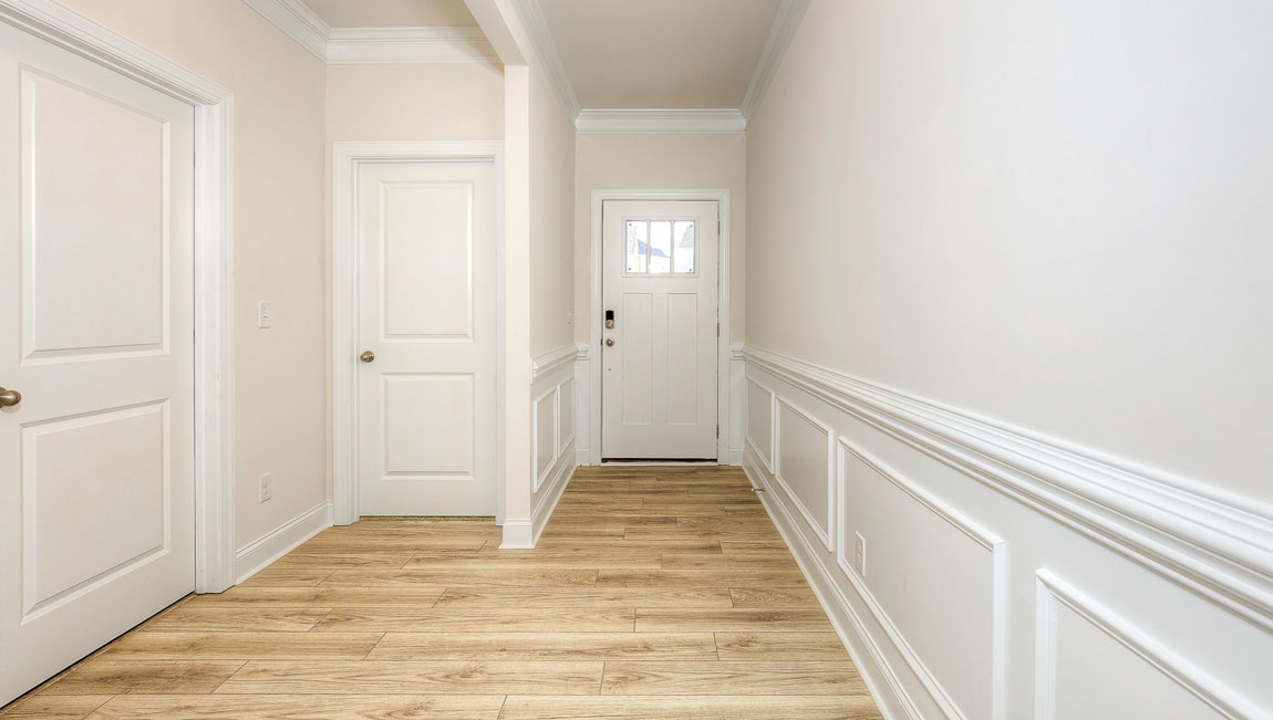 Welcoming foyer with wood floors, view of front door, and edge of dining room