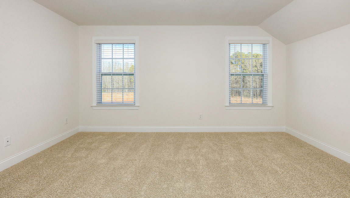 Carpeted bedroom with windows