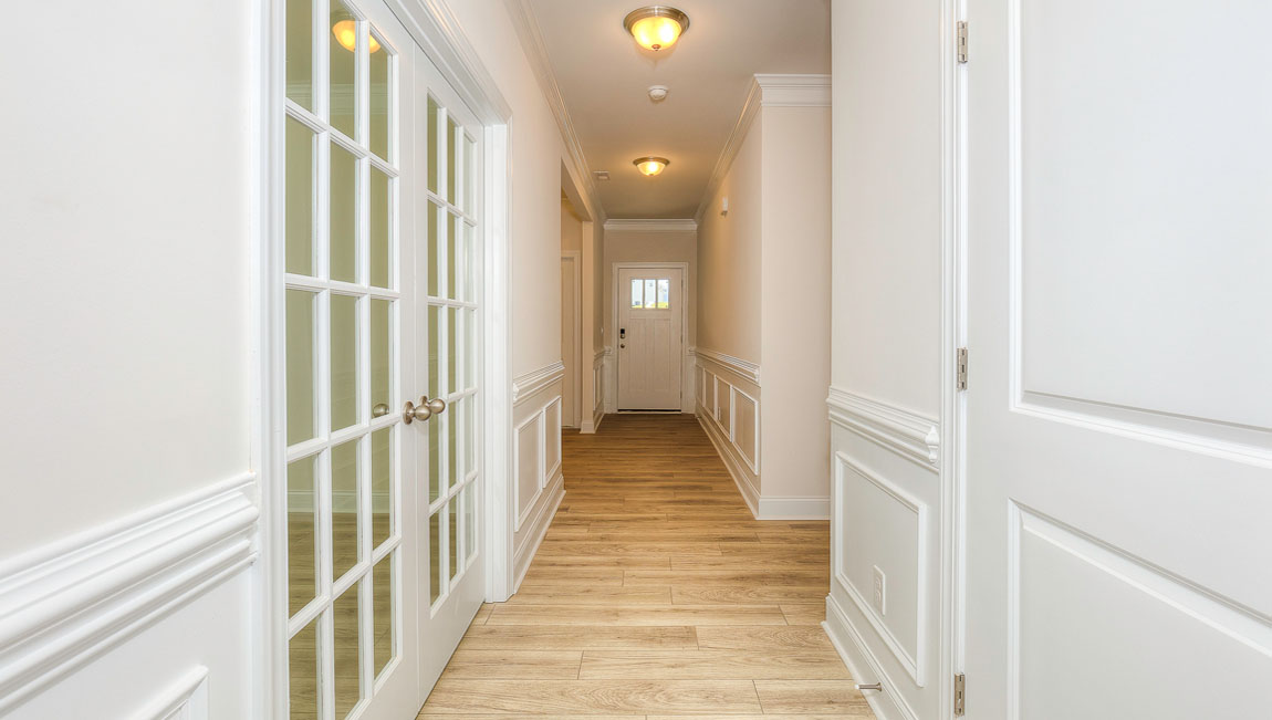 Welcoming foyer with wood floors, view of front door, and edge of dining room
