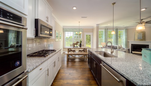 Kitchen and island, wooded floors, and white cabinets