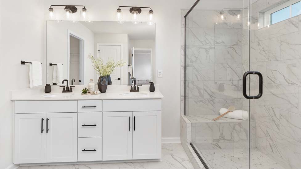 primary bath with walk in shower and double sink vanity