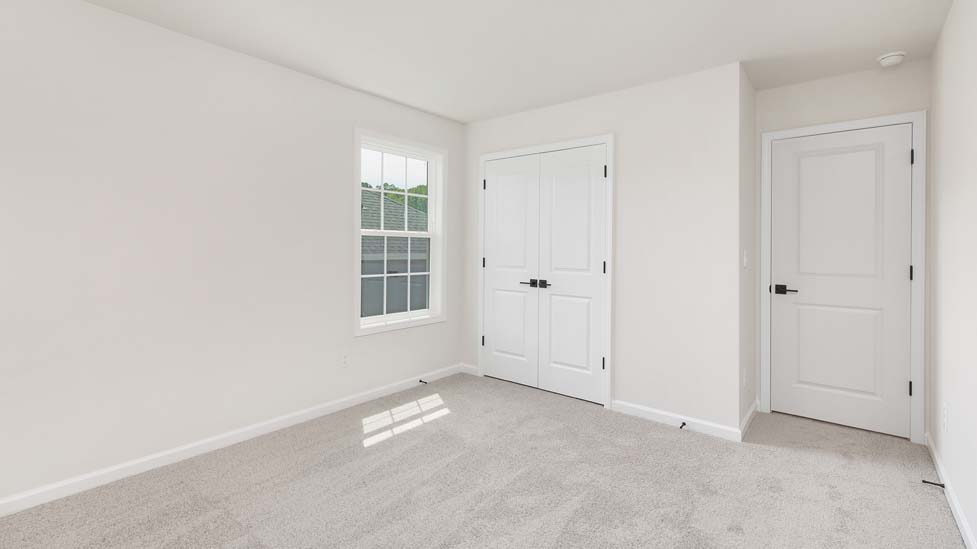 carpeted bedroom with large window