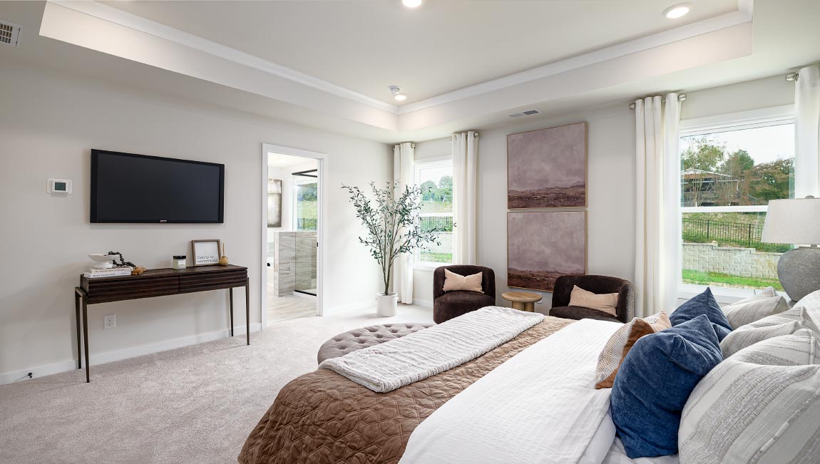 Primary carpeted bedroom with windows