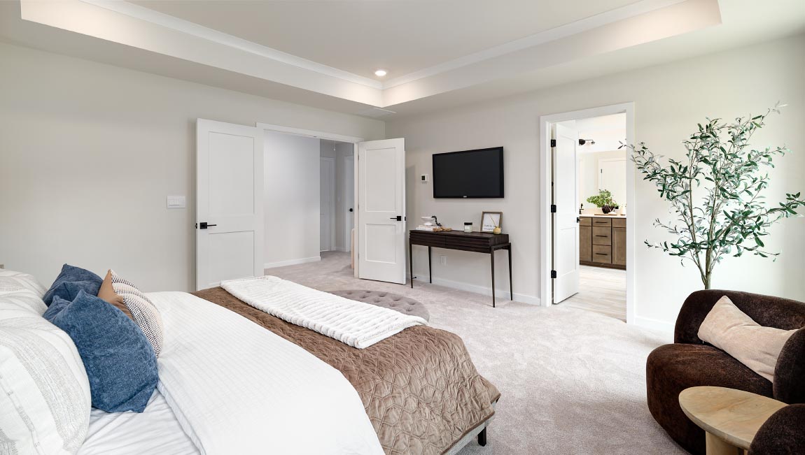 Primary carpeted bedroom with windows