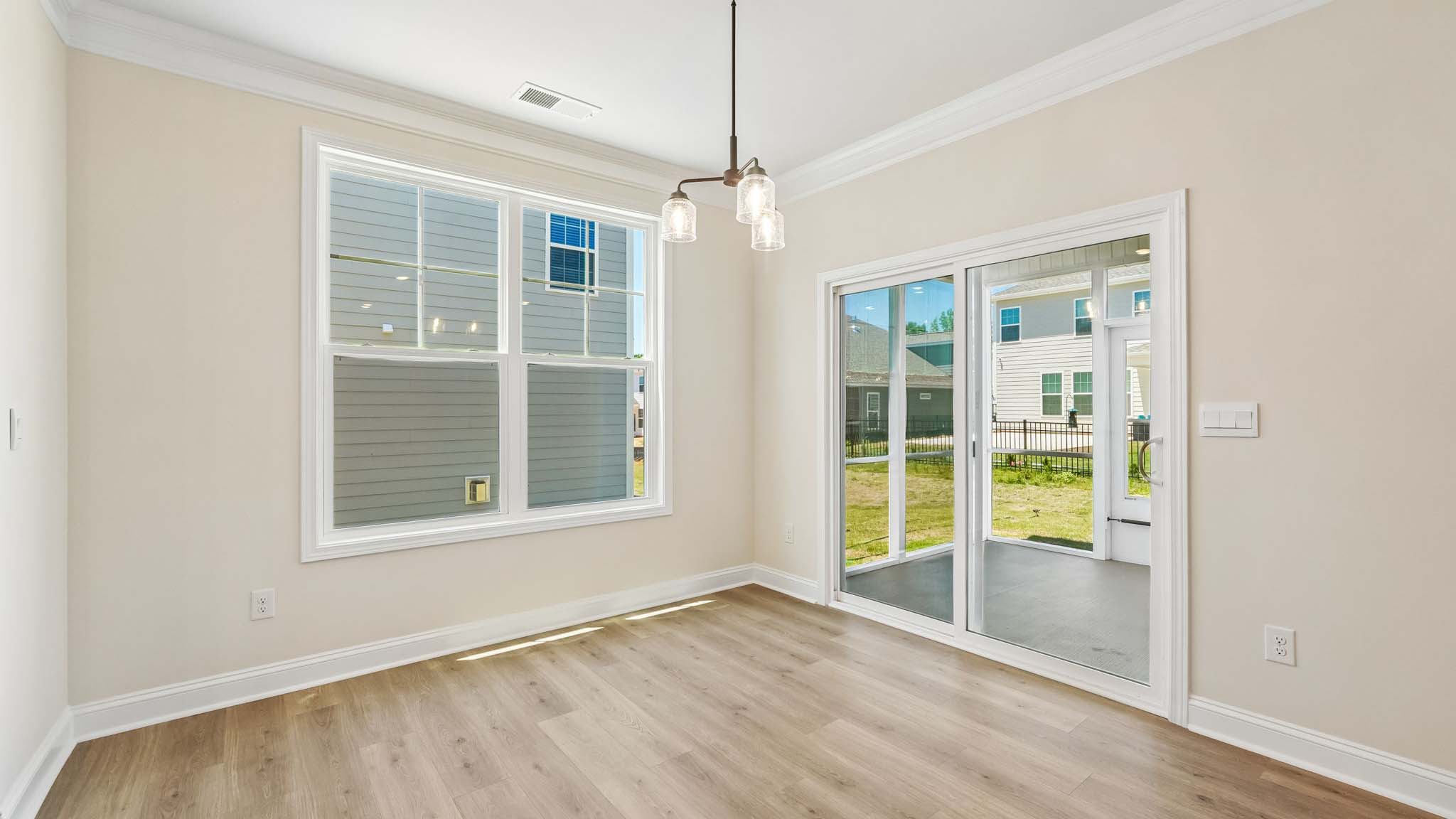 Eating area beside kitchen, wood floors, and sliding glass back door