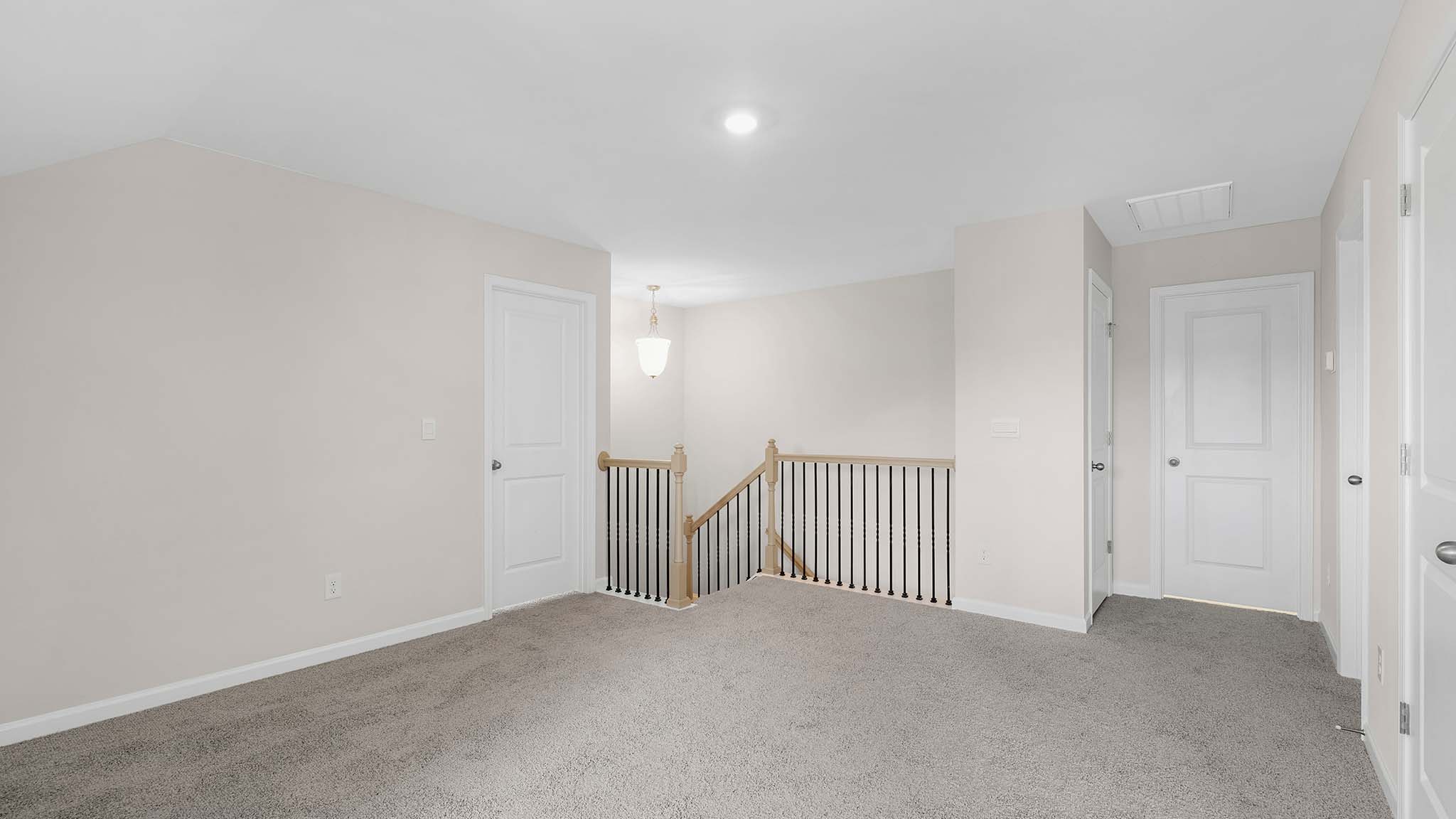 Upstairs carpeted loft space with small window