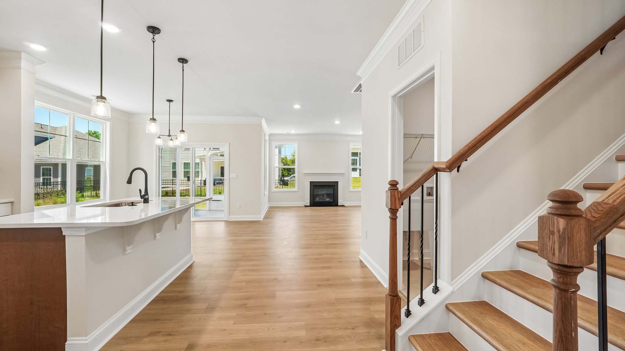 Kitchen and island with wood floors, white cabinets, breakfast area on island bar, and stainless steel appliances