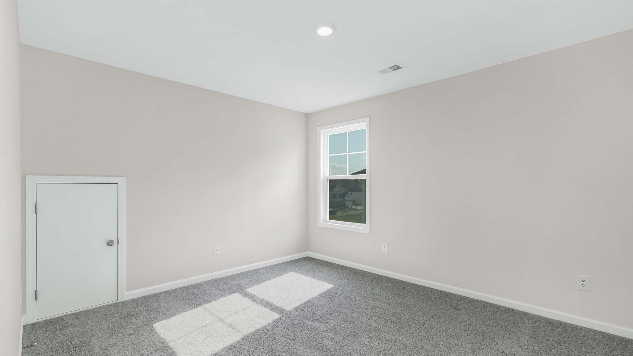 Carpeted bedroom with  small window
