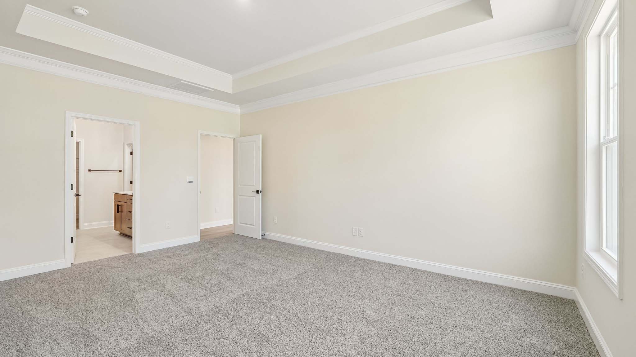 Primary bedroom with carpet, and two large windows