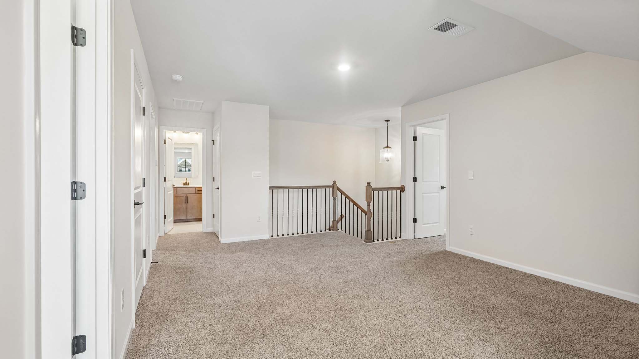 Upstairs carpeted loft space with small window