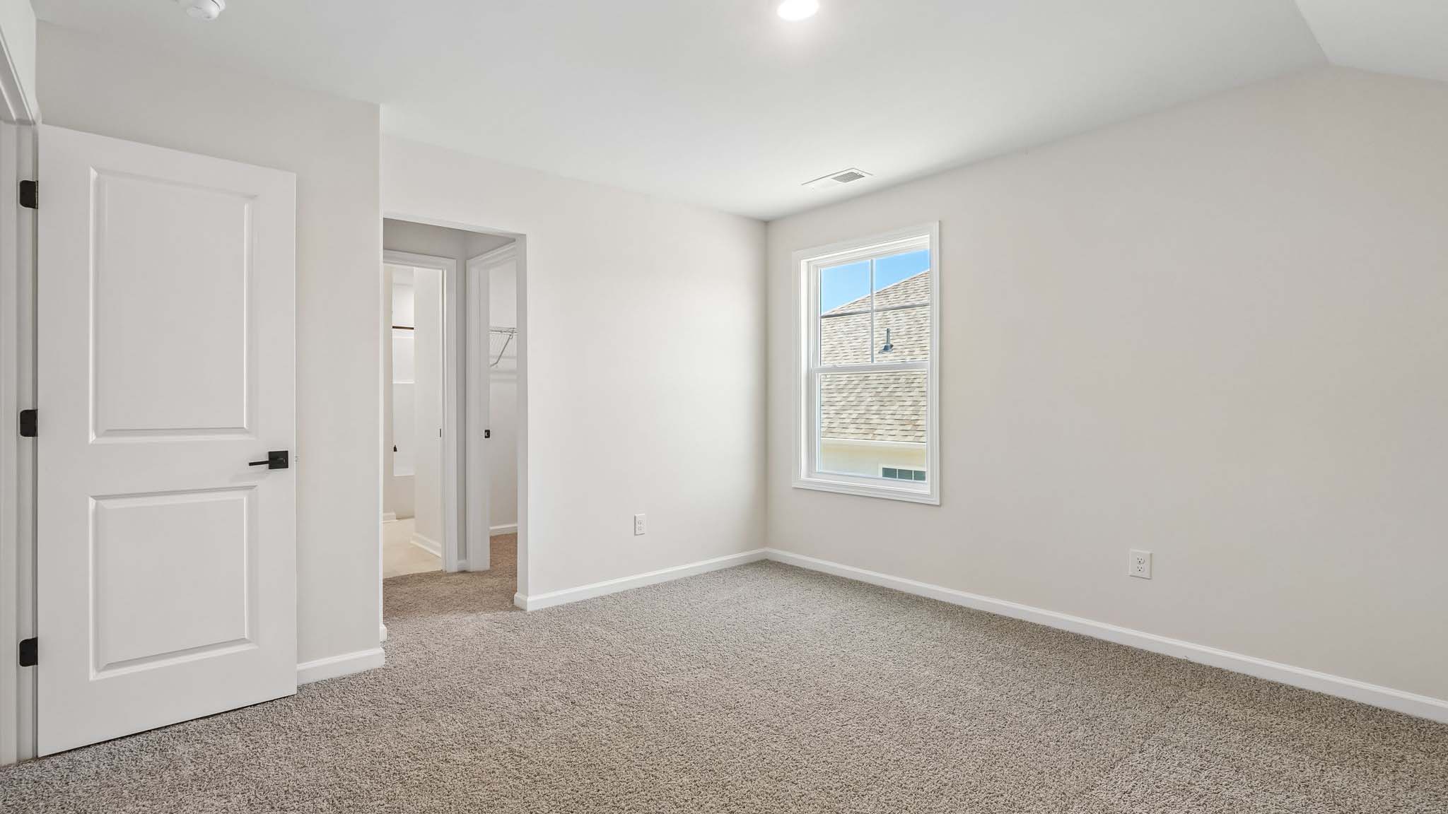 Carpeted bedroom with large windows