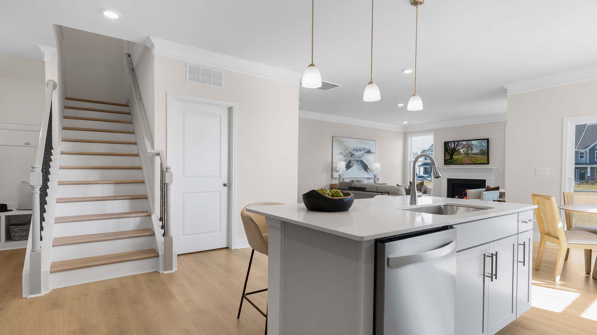 Kitchen and island with wood floors, white cabinets, breakfast area on island bar, and stainless steel appliances