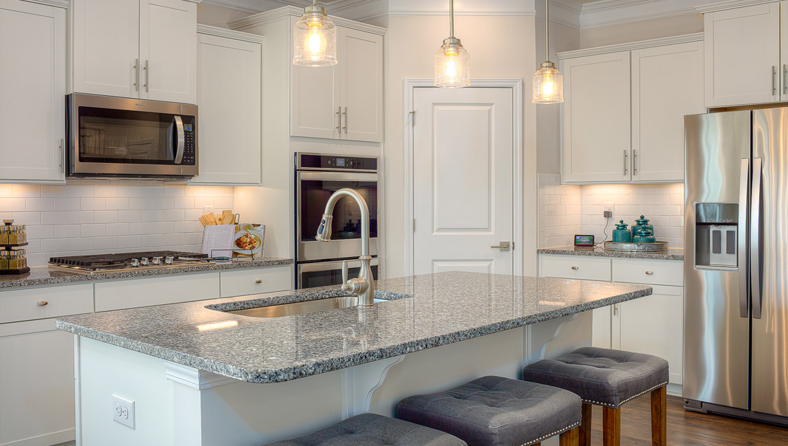 Kitchen and island with wood floors, white cabinets, breakfast area on island bar, and stainless steel appliances