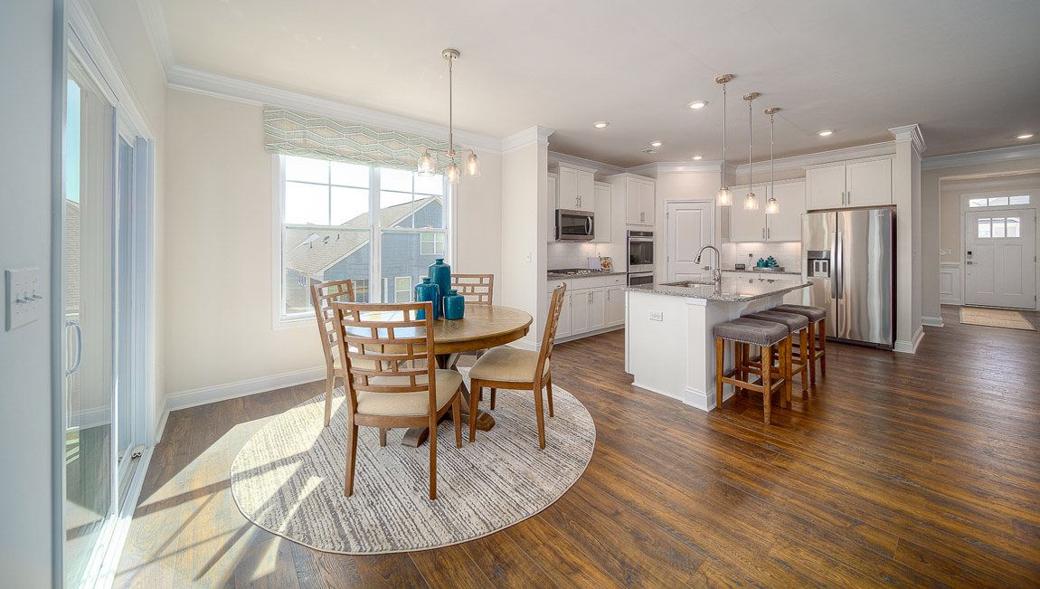 Eating area beside kitchen, wood floors, and sliding glass back door