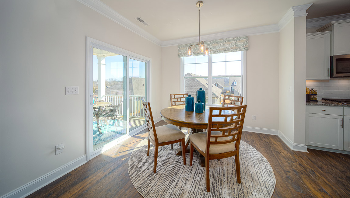 Eating area beside kitchen, wood floors, and sliding glass back door