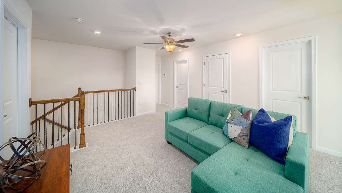 Upstairs carpeted loft space with small window