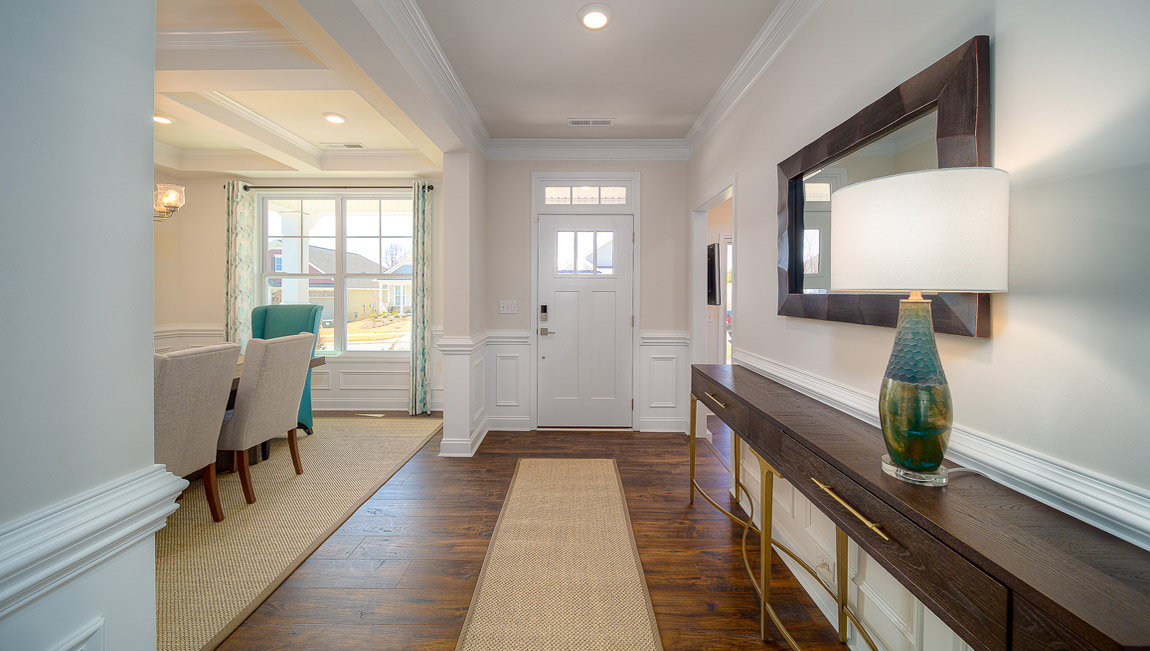Welcoming foyer with wood floors, and view of entrance hallway