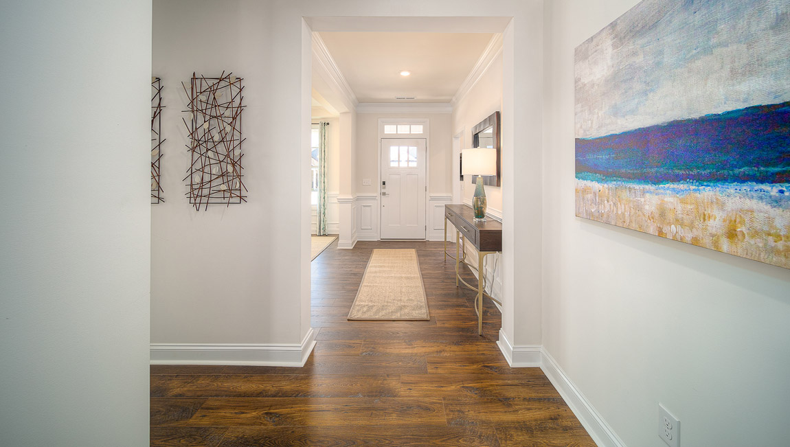 Welcoming foyer with wood floors, and view of entrance hallway