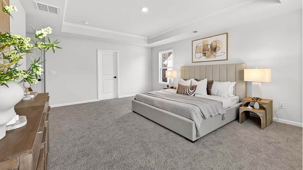 Primary bedroom with carpet and large windows