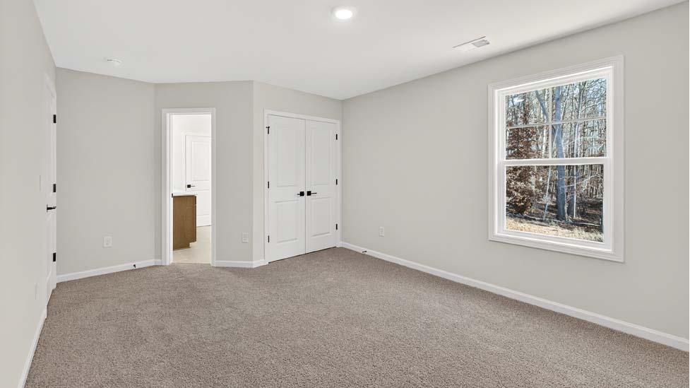 Carpeted bedroom with small window