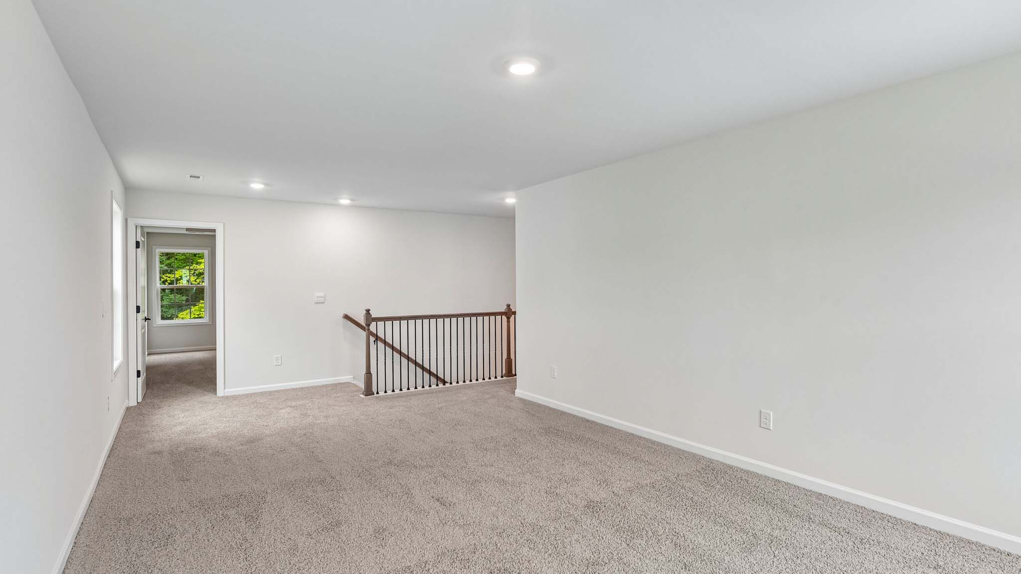 Carpeted loft with windows