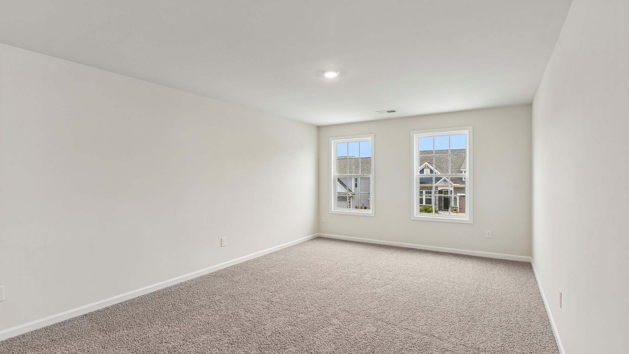 Carpeted loft with windows