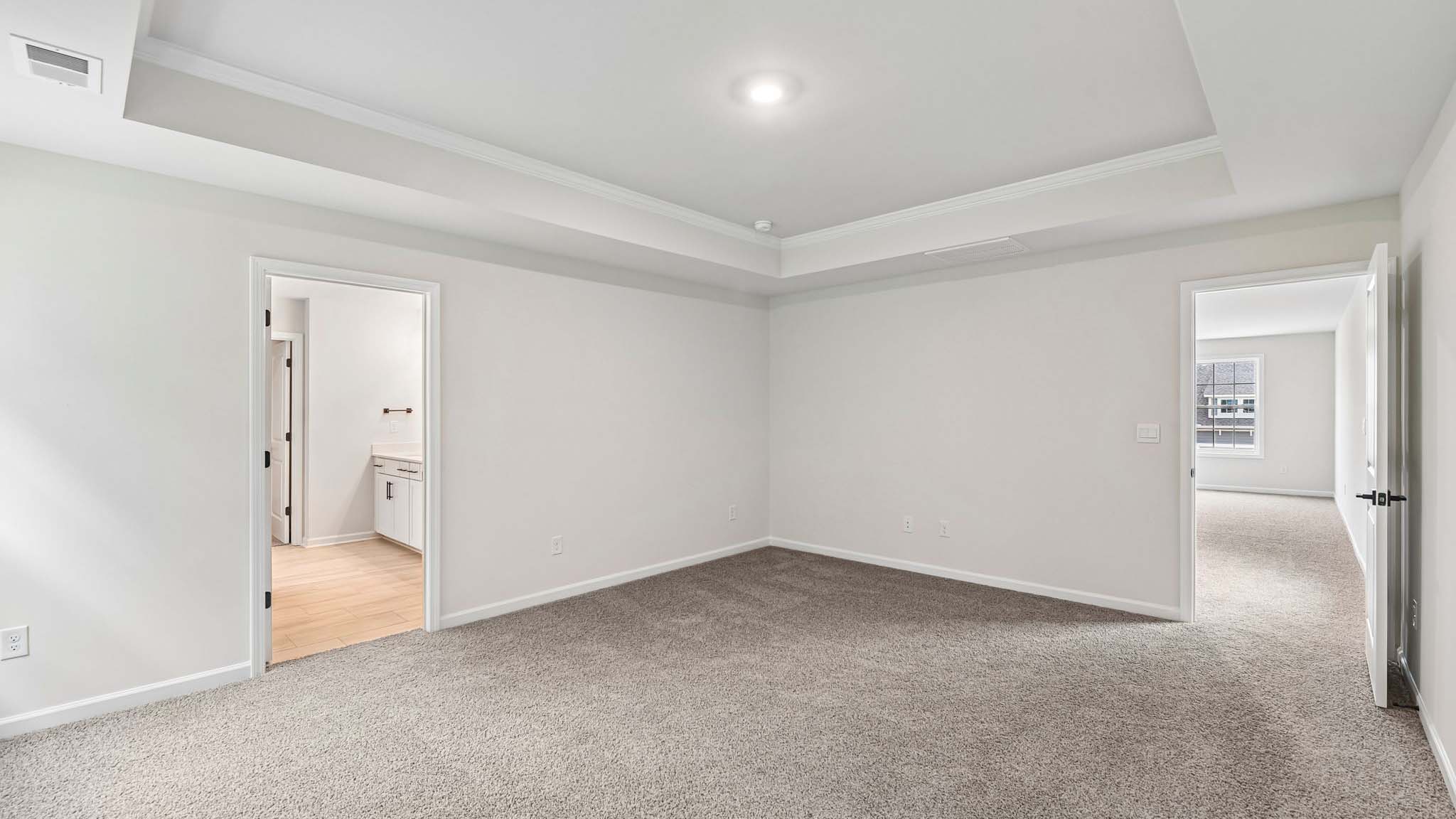 Primary carpeted bedroom with windows